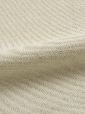 Apricot washed cotton fleece of the oversized graphic hoodie in soft folds, close-up of the brushed surface