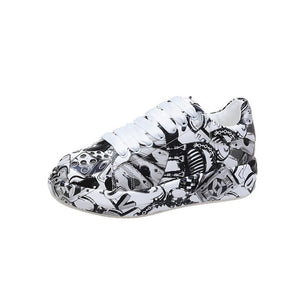 Black painted Y2K platform sneaker alone on white, three-quarter view of the doodle print
