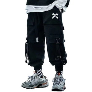 Person wearing black cargo pants with a brand logo on a bridge