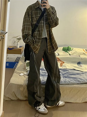 Vista de cuerpo entero en el espejo de los pantalones grises con una camisa de cuadros, piernas anchas y rectas y cordón en el bajo