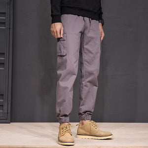Dark Grey Patch Pocket Techwear Joggers, front view with a drawstring waist, thigh patch pocket and suede boots
