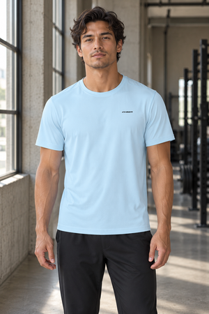 Man in the Light Blue Perforated Back Athletic T Shirt, front view in a gym with a small chest wordmark
