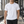 White perforated back workout tee worn front walking view in a gym, small black chest wordmark
