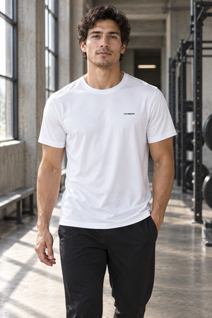 White perforated back workout tee worn front walking view in a gym, small black chest wordmark