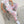 Woman sitting on a wire chair in pink camo sweatpants with a white graphic tee, elastic ankle cuffs