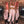 Mirror selfie of a woman in a pink camo crop top and matching baggy sweatpants with black boots