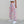 Side view of the Pink Camo Y2K Sweatpants with a white crop top, baggy leg cuffed above white sneakers