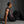 The model sits with one arm back, the cut-away armhole opening over the shoulder