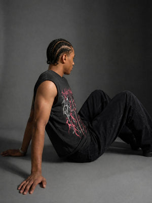 The model sits with one arm back, the cut-away armhole opening over the shoulder