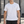 Man in the White Piped Seam Athletic T Shirt, front view in an outdoor gym with a small chest logo