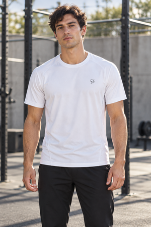 Man in the White Piped Seam Athletic T Shirt, front view in an outdoor gym with a small chest logo