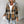 Brown plaid shacket with a grey jersey hood and button front, worn open with ripped jeans, front view