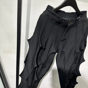 Black pleated harem pants in cotton with tassel detailing