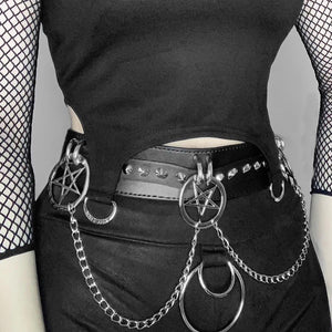 Side view of the PU leather goth shorts on a model in a black top, chains hanging from pentagram rings