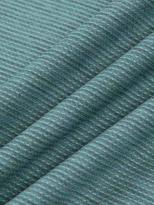 Teal Green knit fabric of the long sleeve gym shirt in folds, showing the fine striped heather texture