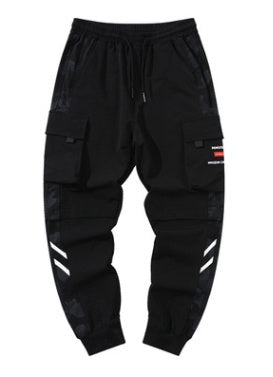 Reflective Stripe Techwear Joggers laid flat, front view with buckle flap cargo pockets and white diagonal shin stripes