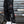 Black techwear cargo joggers in a side view with white sneakers, thigh pocket with red label and white shin stripes