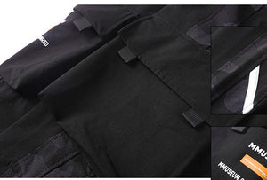 Close-up of the black cargo pocket flap, buckle tabs and dark camo side panel, with an inset of the shin stripe