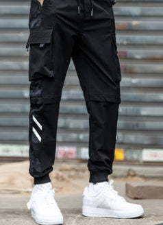 Second front view of the black cargo joggers with dark camo side panels, white shin stripes and ribbed cuffs