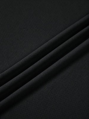 Close-up of the black polyester knit in folds, the smooth fabric of the reflective trim gym tee