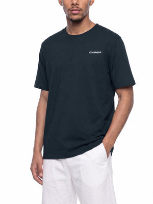 Gray Blue training tee worn in a three-quarter front view, one hand in the pocket of white shorts