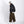 Side view of the oversized black PU leather jacket with wide brown cargo pants and white sneakers