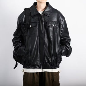 Black PU leather jacket zipped over a bag strap, front view of the zip, side pockets and elastic hem