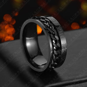 Roman Chain Techwear Ring in black, side view of the chain band on a dark surface with warm lights