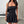 Ruched Bandeau Y2K Dress in black, front view of the strapless ruched bodice with a shoulder bag