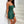 Ruched Bandeau Y2K Dress in green, side view leaning against a white staircase wall