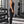 Side view of a model in the black halter yoga top and leggings, V neckline and fitted waist-length hem