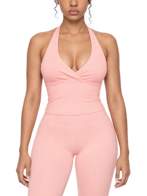 Front view of the pink halter yoga top on a model, fitted body ending at the waist, with matching pink leggings
