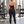 Back view of the black halter yoga tank on a model by the weight rack, small logo and high-waisted leggings