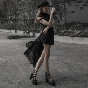 Γυναίκα στριφογυρίζει με το μαύρο διάφανο goth φόρεμα, με τη φούστα από σιφόν να ανεμίζει πάνω από την κοντή εφαρμοστή βάση