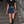 Model walking down graffiti stairs in the Navy Blue side slit tennis skirt, black crop tee and black boots