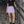 Model on concrete stairs in the Lavender side slit tennis skirt and black crop tee, hand on the rail