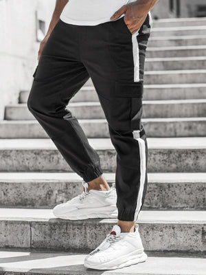 Μαύρο jogger cargo με ρίγα σε πλαϊνή όψη στα σκαλιά, λευκή ρίγα από το ισχίο ως το μπατζάκι στον αστράγαλο και τσέπη με καπάκι στον μηρό