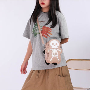 Modella in t-shirt grigia e gonna marrone con la borsa a tracolla skeleton beige con tracolla beige, vista frontale