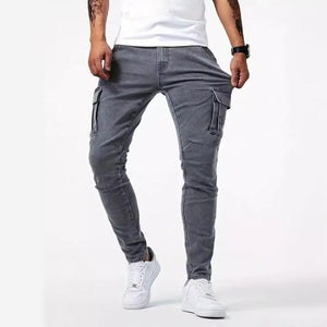 Man in gray skinny cargo jeans with a white tee, front view of the slanted pockets and thigh flap pockets