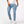 Light blue skinny jeans with cargo pockets, front view of a man walking in white sneakers