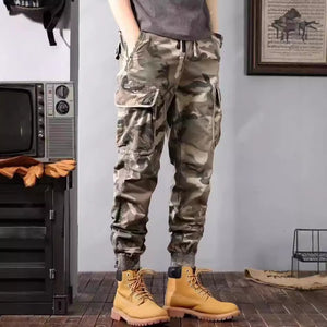 Khaki camouflage cargo joggers with a drawstring waist, front view of the flap thigh pockets