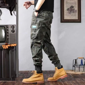 Side view of the green camouflage cargo pants in motion, tapered leg and cuffed ankle above boots