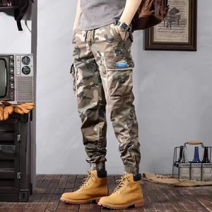 Khaki camo tapered cargo pants worn with a grey tee, front view of the cargo pocket and blue label
