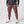 Rust Red Slim Fit Techwear Joggers worn by a man, front view with flap cargo pockets, ribbed cuffs and white shoes