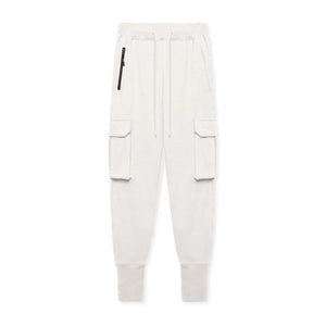Milky White slim fit joggers shown from the front, black zipped hip pocket, flap cargo pockets and long cuffs