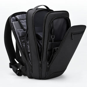 Slim Laptop Techwear Backpack in black opened wide with a laptop inside, below a flat lay of work gear