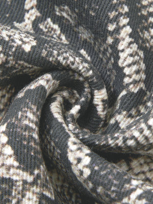 The snake print twisted close up, cream scales breaking over a charcoal ground