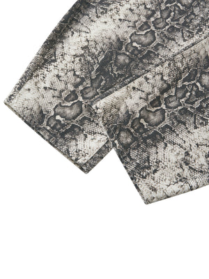 Close-up of the hem, cut straight and left uncuffed so the leg stacks over the shoe
