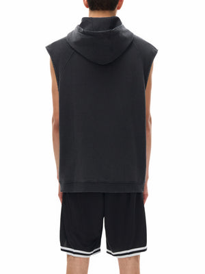 Man wearing the Snow Washed Gothic Hooded Vest from behind, hood down, over black mesh basketball shorts