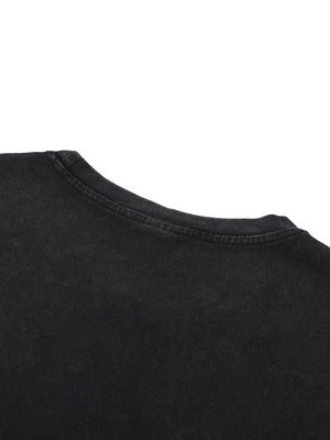 Close-up of the shoulder and neckline, the wash lifting the black towards a dusty grey